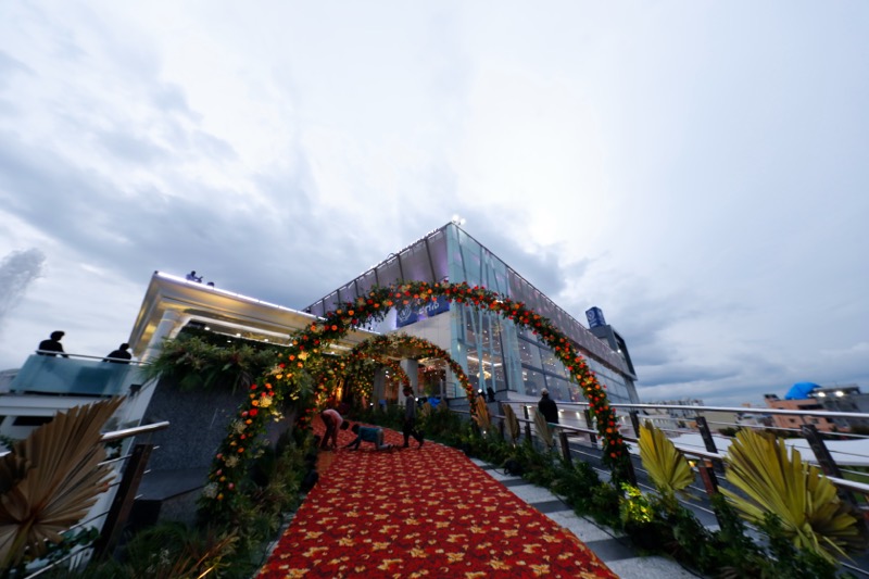 Floral arch over the red carpet with the glass facade behind