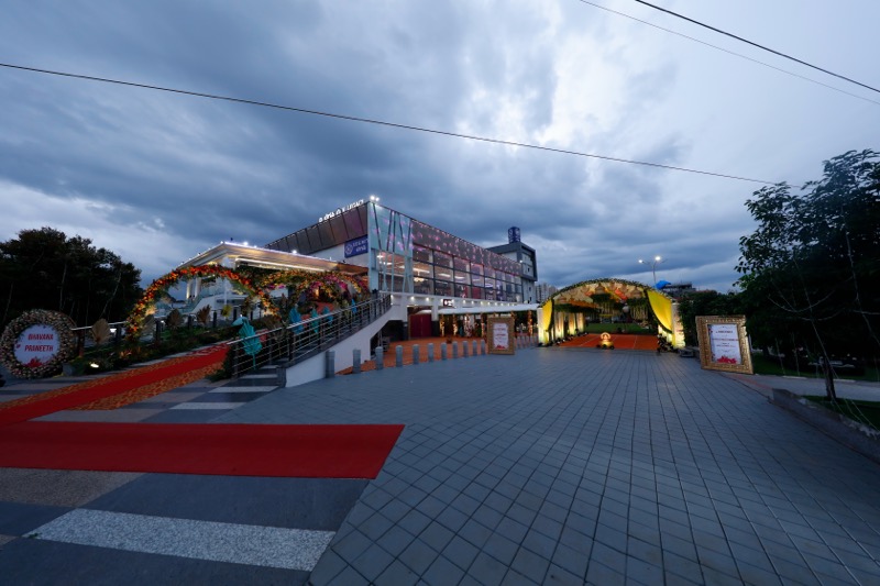 V Legacy facade and forecourt lit at dusk
