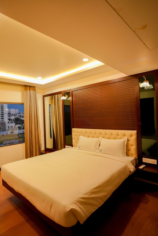 King room with warm cove lighting and a city view